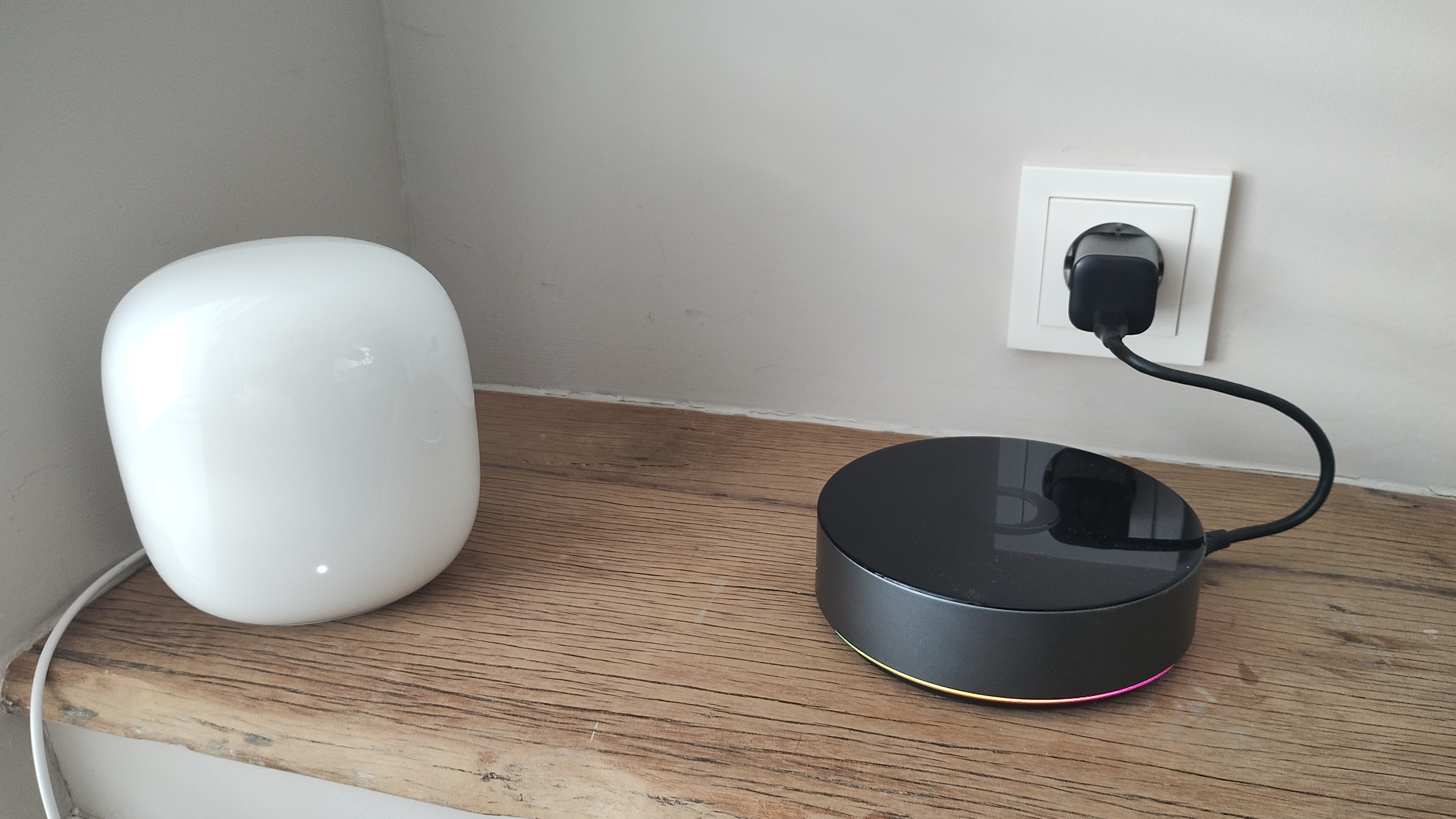 Nest Wifi Pro naast een Homey op een houten plank